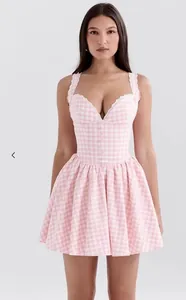 Detail of pink plaid dress featuring white lace trim and corset-style bodice texture