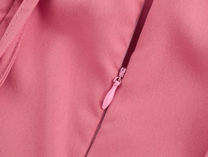 Gros plan détaillé d'une fermeture éclair invisible sur une robe courte rose à lacets