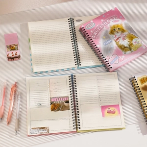 Detail of pink spiral notebook inner pages with daily plan sections and cat illustration