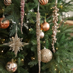 Sparkling gold Christmas ornaments set featuring stars and glittery baubles on tree