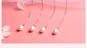 Detail view of S925 silver and gold pearl earrings with teardrop pearls on soft mesh