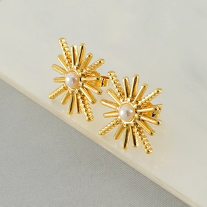Detail of 18K gold plated sunburst stud earrings with centered white pearls