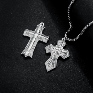 Vintage silver cross pendant necklaces with crown detail and embossed textures on dark background