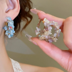 Detail of bohemian silver needle hoop earrings with colorful irregular natural stones