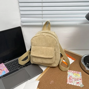 Minimalist beige corduroy mini backpack with adjustable straps on a modern desk setup