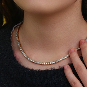 Élégant collier tennis doré avec cristaux de zircone carrés porté par un modèle