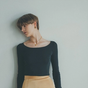 Detail of a vintage double-layer gold-plated brass necklace on a black knit sweater