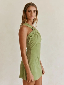 Front view of grass green sleeveless mini dress with twist knot halter neck design