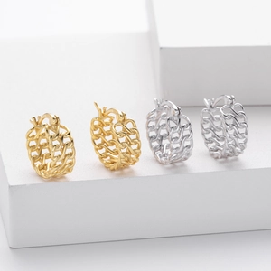 Detail view of gold and silver chain link hoop earrings on white geometric stands