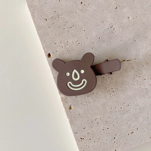Close-up of a cute brown mushroom hair clip on a natural stone surface for girls