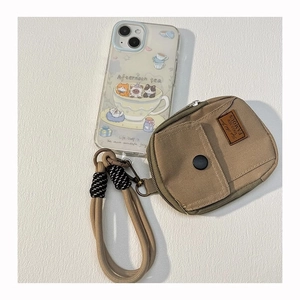 Detailed macro view of a brown canvas mini backpack keychain with a metal clip and strap