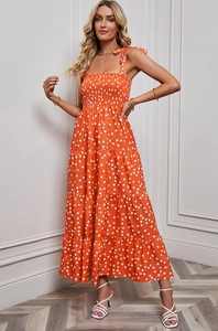 Detail of orange polka dot maxi dress featuring tiered skirt and tied shoulder straps