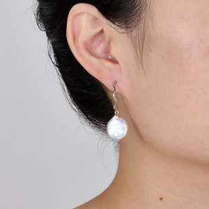 Close-up of S925 sterling silver C-shaped earrings with white baroque pearl on model