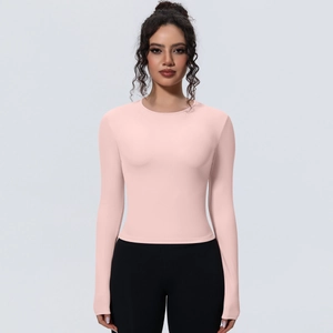 Détail du haut de yoga rose ajusté montrant le tissu élastique et l'encolure ronde