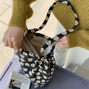 Detail of floral corduroy tote bag with snap button closure in daily lifestyle setting