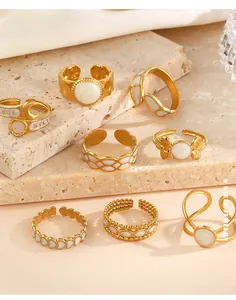Detailed set of 8 golden stainless steel rings with white enamel and heart motifs