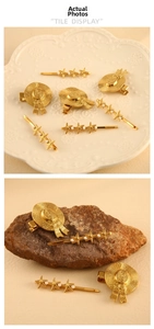 Detailed view of golden straw hat hairpin and starfish pearl clip on natural stone base