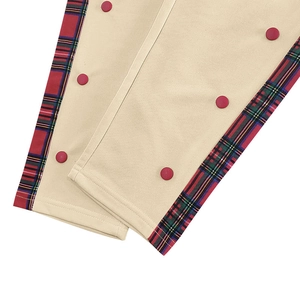 Detail of plaid hem with decorative red button on beige casual straight pants