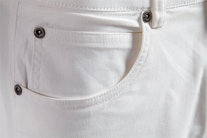 Gros plan sur un short en coton blanc avec rivets métalliques et double couture fine