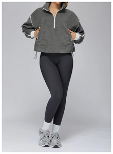 Detailed texture of dark grey fleece sweatshirt with drawstring hem and stand collar