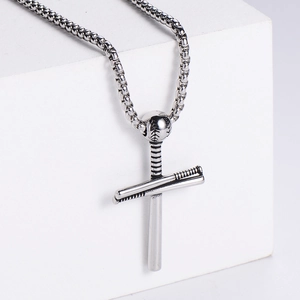 Detailed macro view of silver stainless steel baseball cross pendant with fox chain