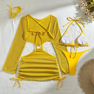 Detailed flat lay of a yellow three-piece bikini set with sheer mesh cover-up and accessories