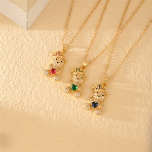 Detailed view of three gold teddy bear necklaces with red, green, and blue heart gems