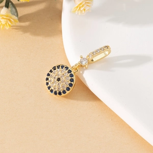 Macro shot of gold Evil Eye pendant with blue and white zircon stones and inlay details