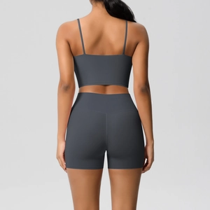 Detail of high-stretch dark gray yoga set featuring cross-back sports bra and biker shorts