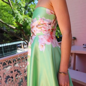Detail-Seitenansicht des Satin-Schulterkleides mit grünem Blumendruck auf dem Balkon