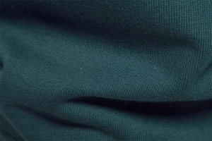 Macro shot of dark green high-density knit fabric showing soft texture and premium weave