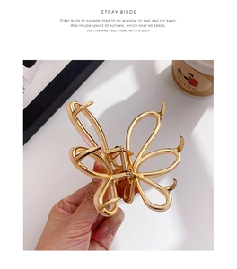 Detail of a hollow gold butterfly hair claw clip with a strong metal spring mechanism