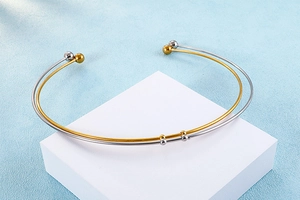 Detail of minimalist two-tone steel collar necklace set on a display stand