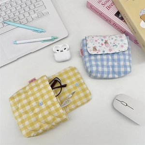 Quilted plaid pouch showing storage for glasses and earphones on a clean desk