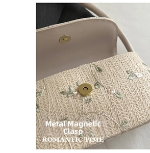 Gros plan du fermoir magnétique doré sur le sac tissé beige avec broderie florale