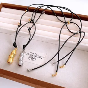 Collana con ciondolo a forma di arachide in oro e argento con cordino nero regolabile