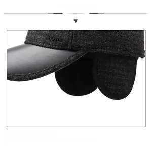 Detail of dark grey winter baseball cap with foldable ear flaps and fleece lining