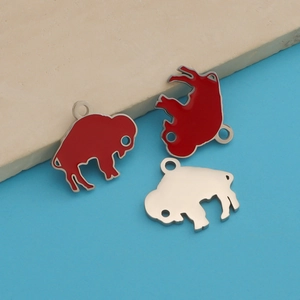 Macro detail of red enamel water buffalo charms on polished stainless steel base