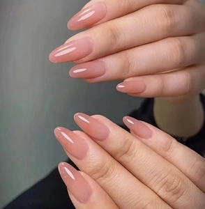 Close-up of glossy translucent jelly pink almond-shaped press-on nails with high-shine finish