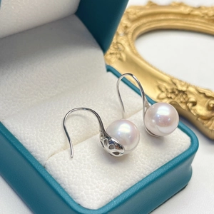 Detailed macro view of freshwater pearl earring with elegant silver S-shaped hook