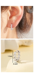 Detail of silver heart-shaped zircon earrings with measurement dimensions and model try-on