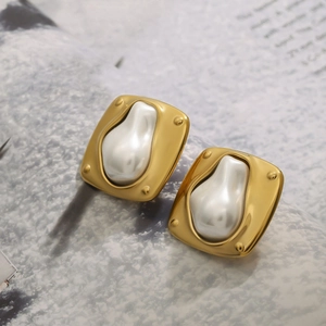 Elegant gold stainless steel earrings with irregular pearl inlay on vintage magazine