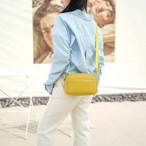 Detail view of bright yellow PU leather crossbody bag with adjustable wide strap for women