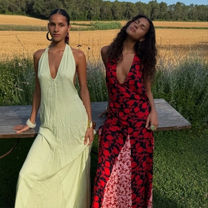 Detail view of deep V-neck backless maxi dresses in solid green and red floral prints