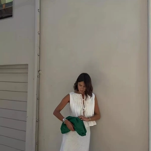Chic green woven leather cloud clutch paired with white sleeveless top for street style