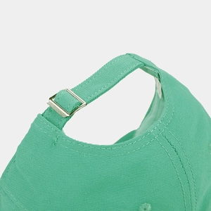 Detail of mint green cotton baseball cap showing adjustable strap and silver metal buckle