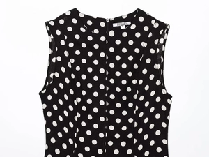 Dettaglio dello scollo dell'abito midi a pois bianchi e neri con cerniera lampo sul collo