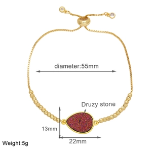 Detail view of adjustable gold-plated bracelet with a red teardrop druzy stone pendant