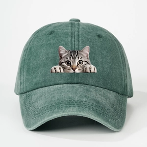 Detail of vintage washed green baseball cap featuring a funny cat graphic on cotton canvas