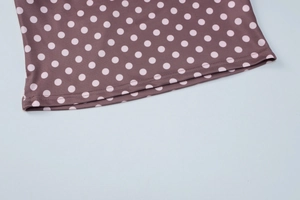 Gros plan sur tissu marron à pois avec des finitions de couture à double aiguille